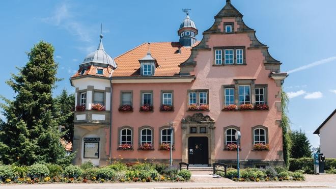 Rathaus bei Sonnenschein von der gegenüberliegenden Seite fotografiert. Blick auf den Haupteingang.